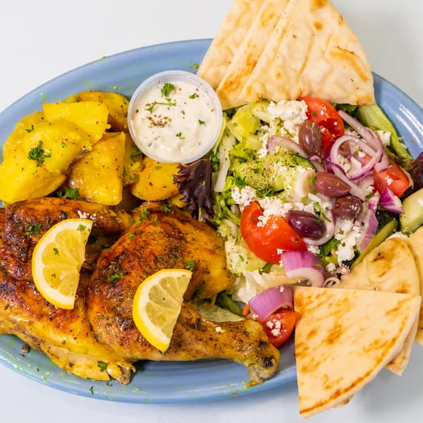 The Fat Greek's roasted chicken with lemon, potatoes, Greek salad, tzatziki, and pita bread.
